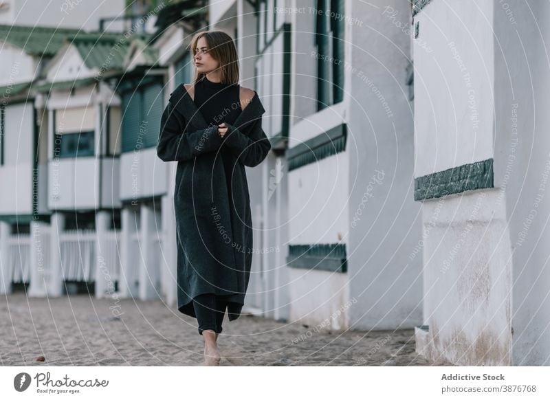 Peaceful woman walking along street in old town mood melancholy city thoughtful dull ancient female pavement stroll pensive solitude alone lonely urban style