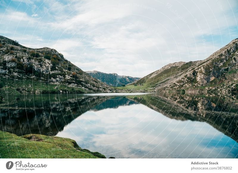 Amazing mountains reflecting in calm lake reflection highland pond surface smooth landscape scenery rock water area nature environment serene peak range mirror