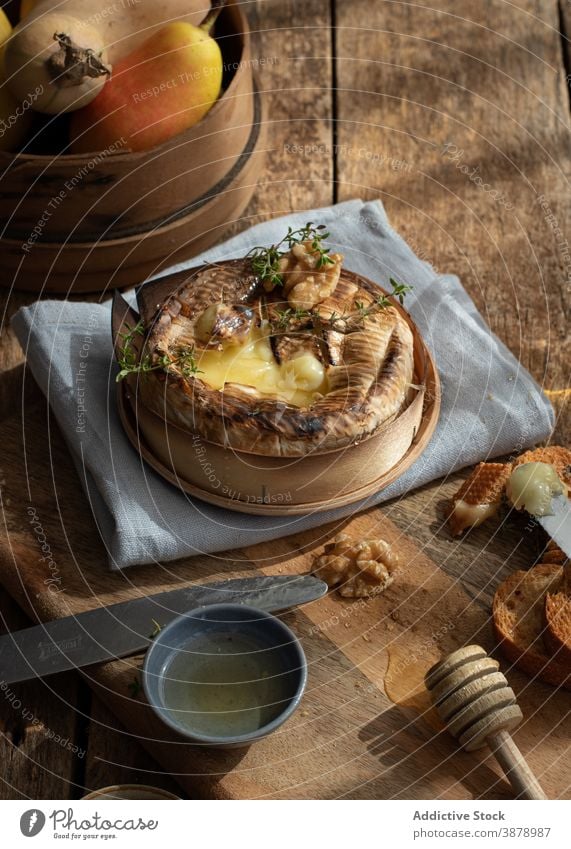 Baked camembert served on wooden table Baked Camembert herbs delicious board crust baguette tasty melted mold organic cooking walnut toast ingredient baking dip