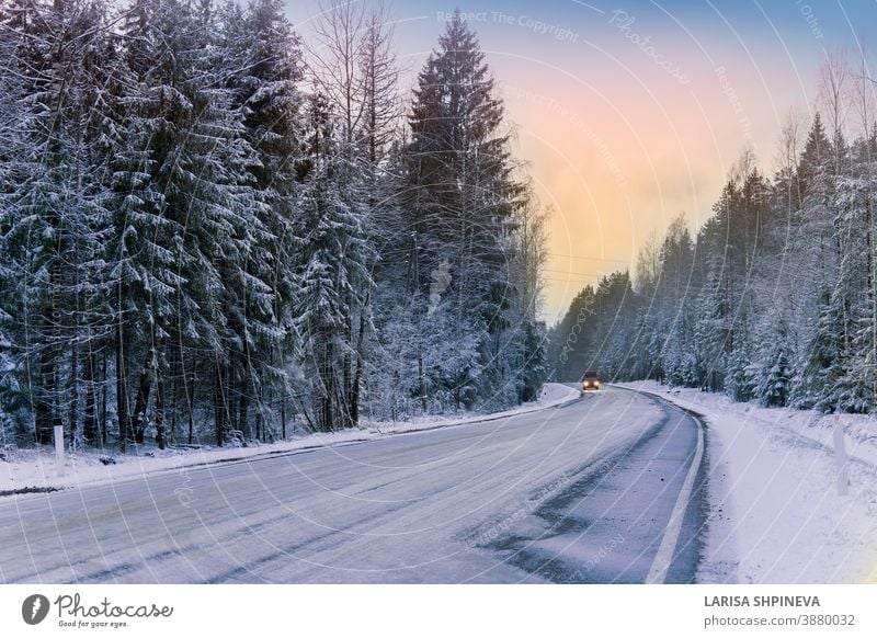 Car drives on empty snowy road in winter forest. Beautiful frosty white landscape at dawn. season ice scene christmas tree day car freeze outdoor background