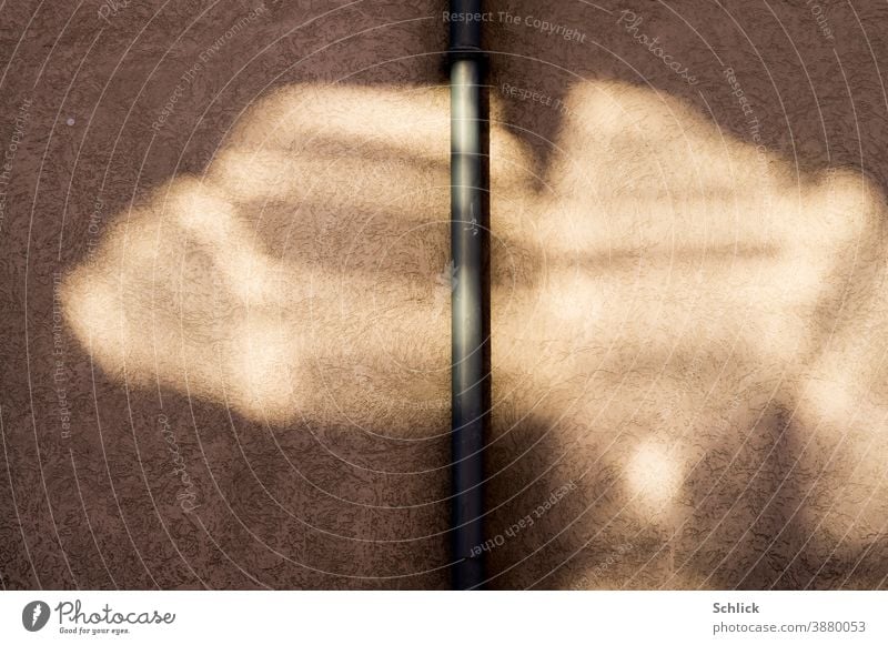 Abstract light reflection of a window against a house wall with rainwater downpipe Light Reflection downspout brown light brown Visual spectacle light beings