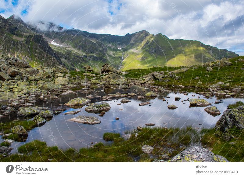 small alpine lake in Tyrol one mountain range outdoor alps clouds valley explorer escape vegetation climbing surrounded hiking amazing journey backpack