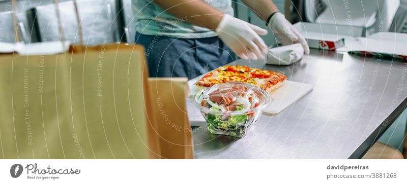 Unrecognizable cook packing takeaway orders restaurant kitchen preparing orders paper bag unrecognizable banner web header panorama panoramic salad