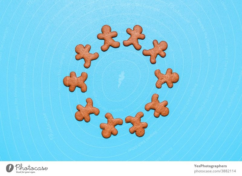 Gingerbread man cookies arranged in a circle on a blue background. above view biscuits celebration christmas copy space cut out decoration dessert festivity