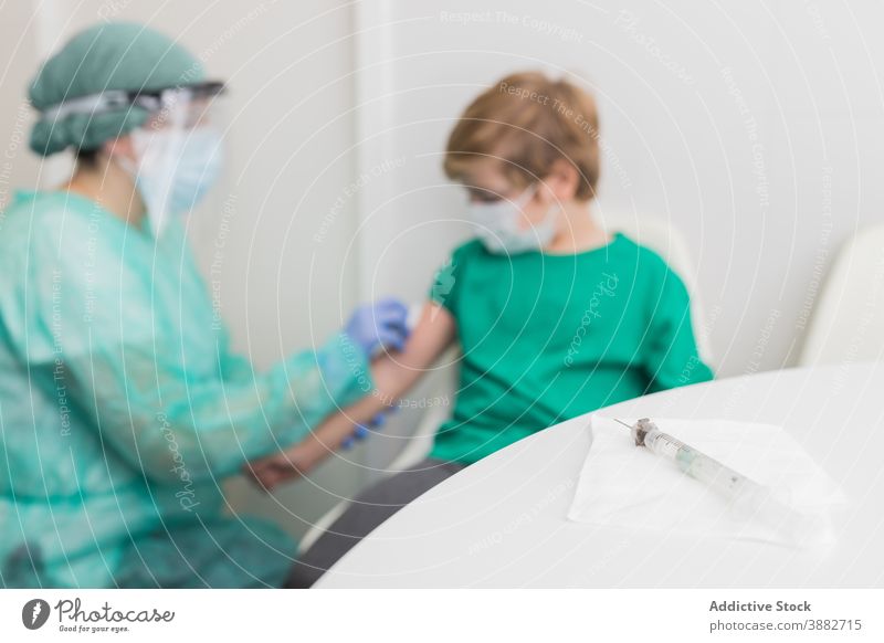 Doctor preparing child for vaccination from coronavirus disinfect injection patient vaccine doctor sterile covid 19 new normal costume medic clinic protect