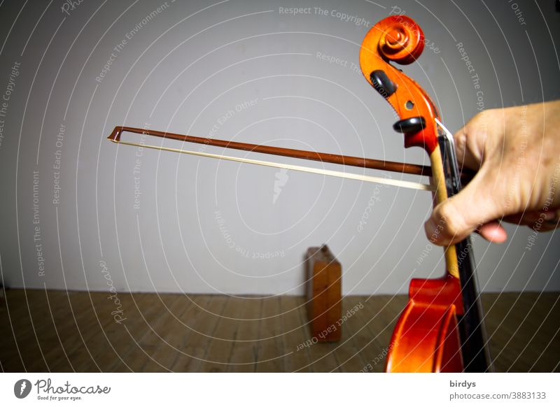 Violin and bow in the hand of the musician in an empty room. Ban on performing in the Corona Crisis Violin bow Hand Room on one's own Music Artist