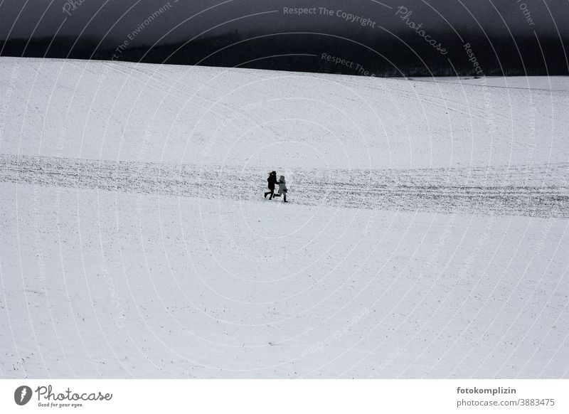 two children running across a snowy field experience together Childhood memory Common ground at the same time Jump Running Happy winter holidays