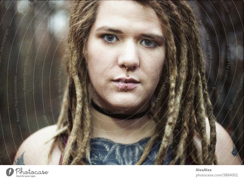 Portrait of a young woman with dreadlocks and tattoos in the forest Woman Dirty Blonde tattooing Jewellery Piercing earring Concealed Direct Nahe Skin