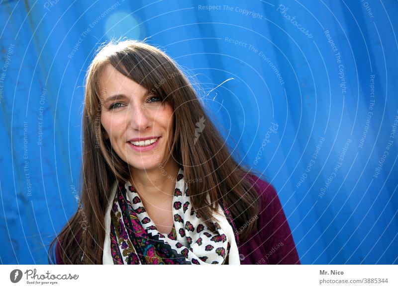 Smiling young woman against a blue background Woman Feminine Long-haired Brunette pretty Contentment Friendliness naturally Sympathy portrait