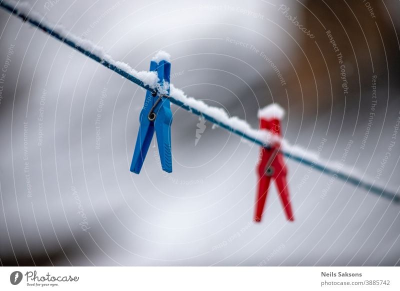 clothes peg on a clothesline in snowy winter day Blurred bokeh cable clamp clench clip close closeup clothespin clothespins clothing color colored colorful