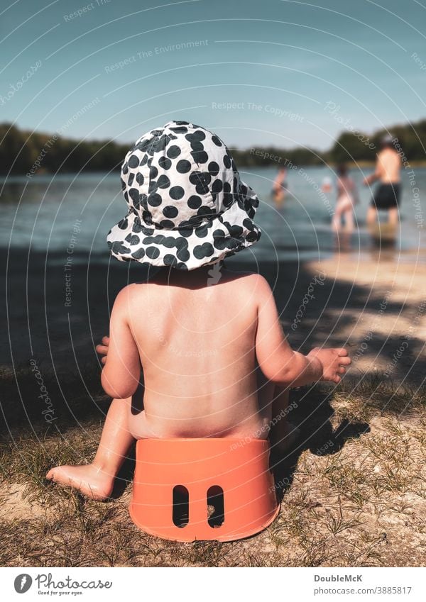 Potty good, all good!  - Child sits on potty at the lake and watches the hustle and bustle in the water Girl Human being Colour photo Exterior shot Day