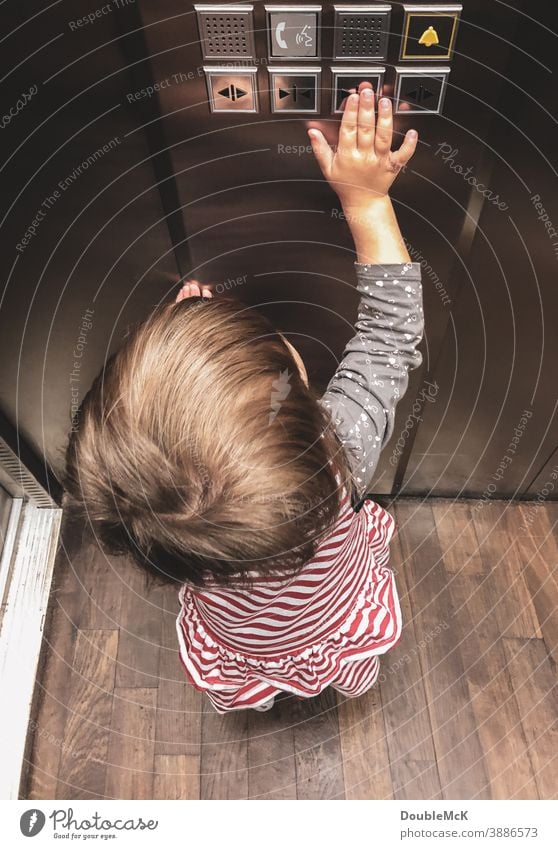 Girl pushes the elevator button and closes the door Child Toddler Colour photo Human being Day 1 - 3 years 3 - 8 years Multicoloured Pushing Elevator