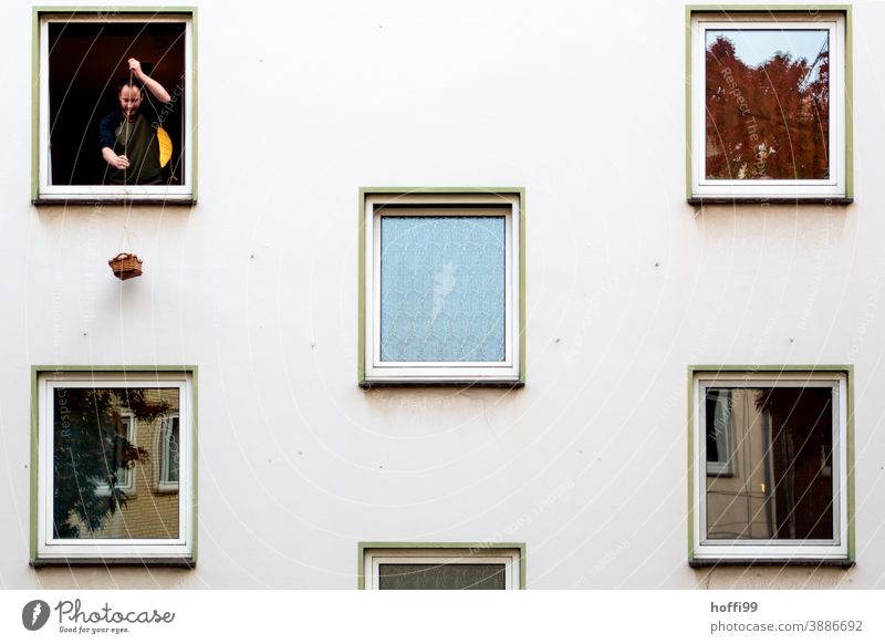 a man at the window pulls up a basket of food Provision Quarantine covid-19 Supply shortfall supplies delivery pandemic coronavirus Infection Illness