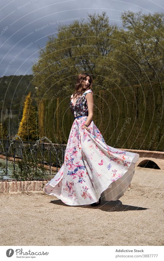 Elegant woman turning around in dress in park spin around turn around grace elegant long dress maxi garden female sunny feminine carefree freedom relax style