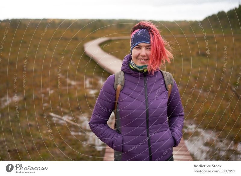 Woman walking along wooden footpath in field traveler backpacker woman adventure warm clothes wanderlust female sestroretsk saint petersburg russia