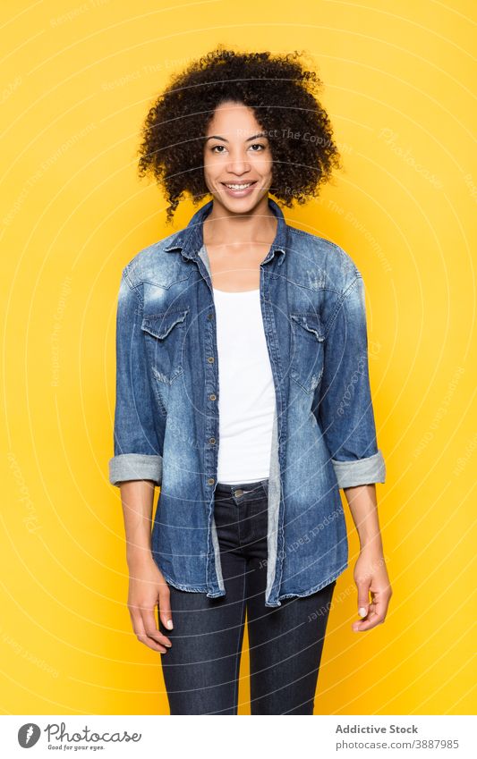 Cheerful ethnic woman in denim shirt looking at camera cheerful smile casual positive trendy happy optimist curly hair young african american black afro style