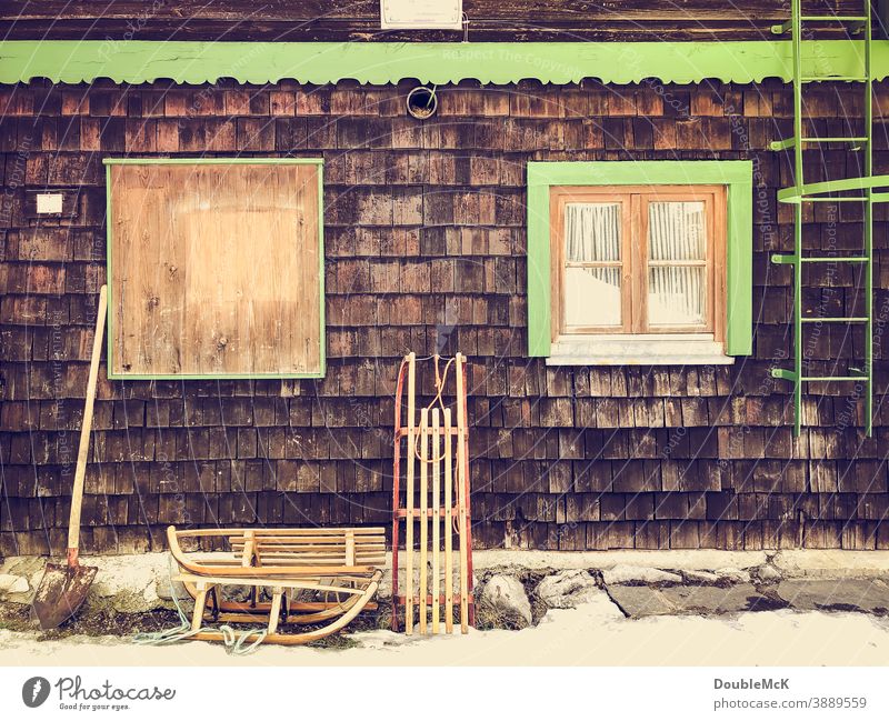 Sledges stand against the house wall Deserted Exterior shot Colour photo Water reflection Calm Day Outdoors Sleigh Parking switch off turned off Parked nailed