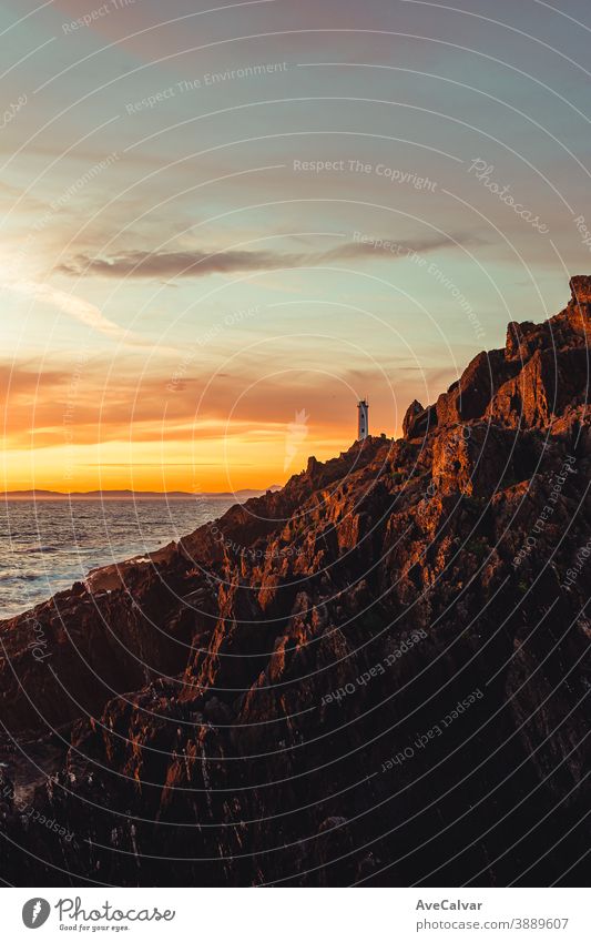 A dramatic view of a white lighthouse from the rocks of the coast color image architecture ocean photography tourism outdoors sea lookout copy space scenic