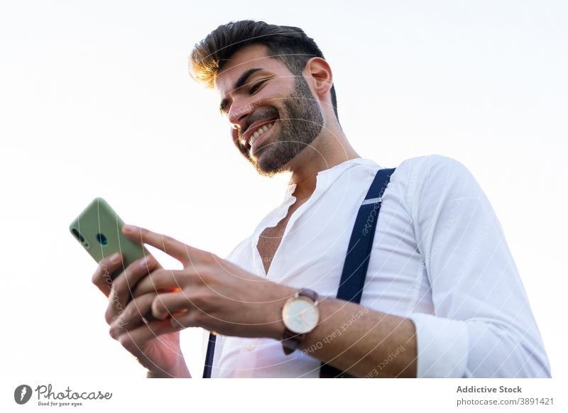 Man in stylish outfit using smartphone in city browsing man street message style trendy handsome smile male mobile communicate chat internet device gadget