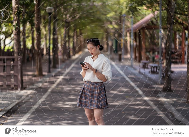 Asian woman walking along bicycle path bikeway lane smartphone browsing city message female ethnic asian tanya shen green bikeway taichung taiwan gadget mobile