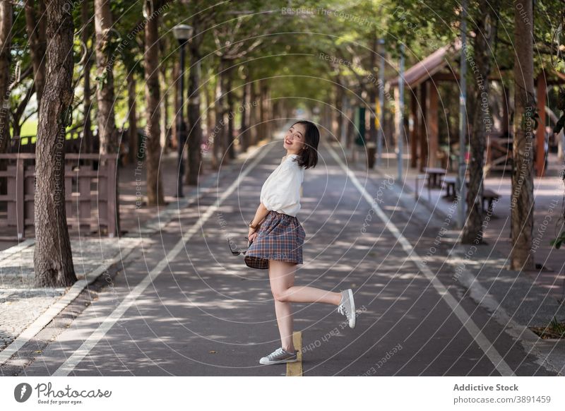 Young Asian woman having fun in urban park coquette carefree summer cheerful smile charming entertain female ethnic asian tanya shen green bikeway taichung