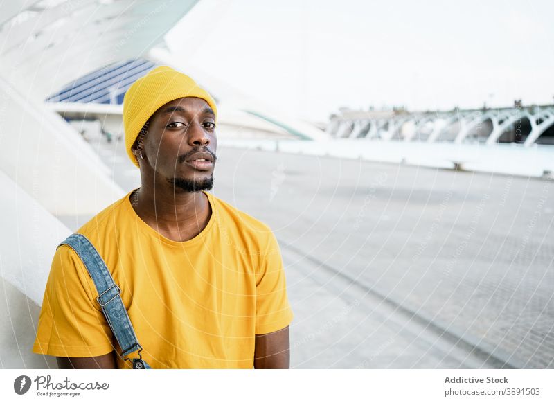 Black man standing in the street looking at camera trendy male ethnic black african american yellow outfit style modern bright appearance garment urban young