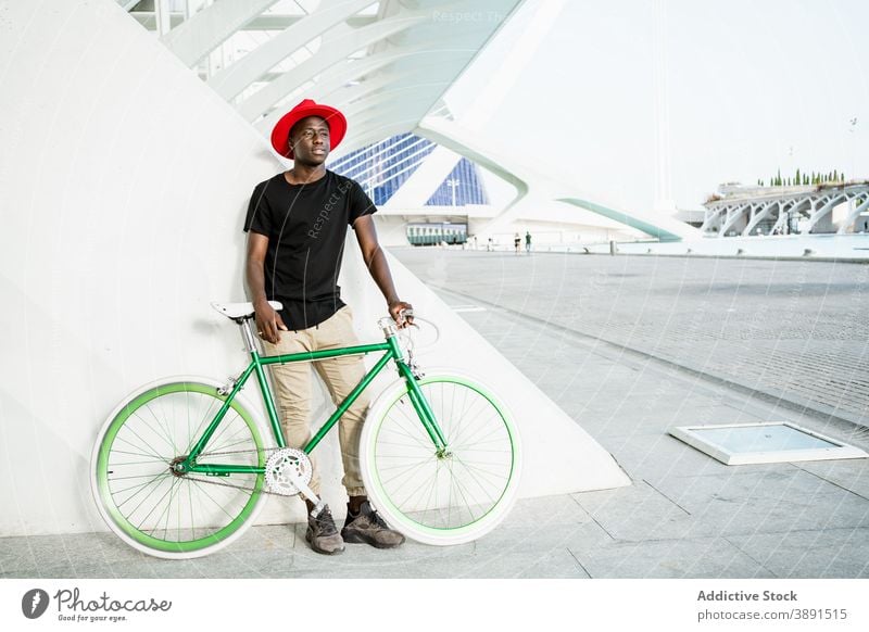 Stylish black man with bicycle in city urban style young bike modern trendy confident male ethnic african american street appearance hipster serious hat cool