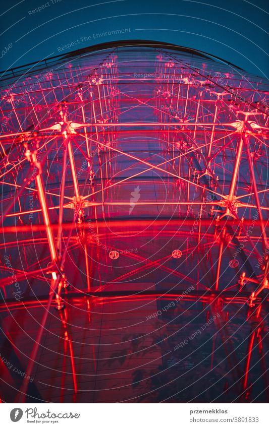 Looking up at modern glass building lighted with red at night clear reflection corporation tall outdoors space color commercial city financial exterior office