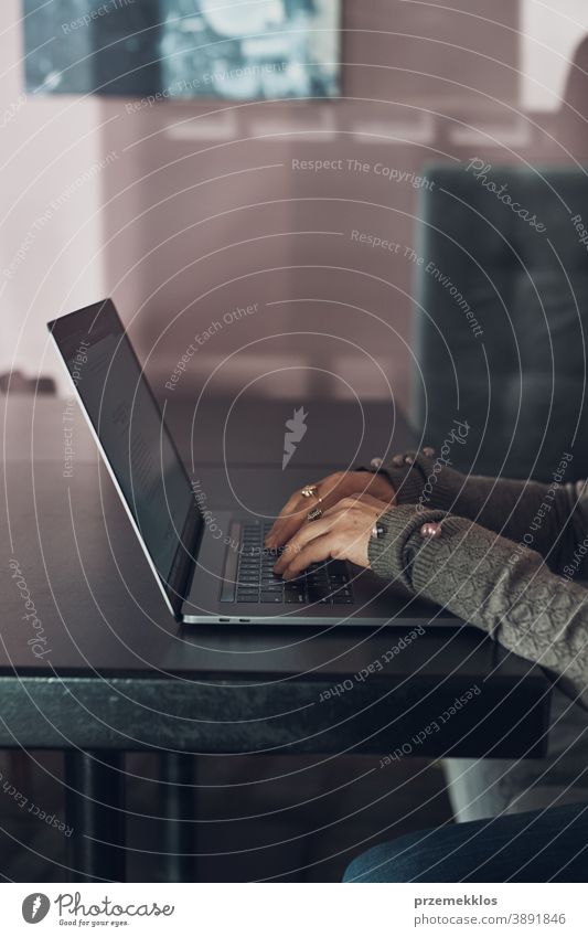 Woman working remotely on her laptop computer managing her work sitting in a cafe business caucasian coffee connection contemplate desk entrepreneur female