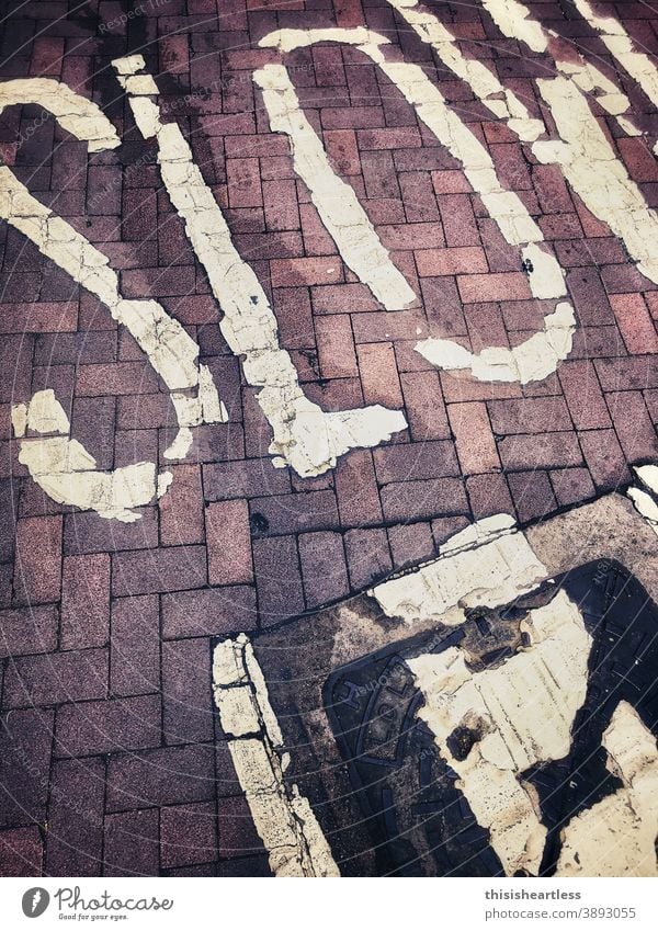 S L O W lettering on red paving stone, Manchester, UK Slowly sluggishness slow life propel slowly slow down slowly like a snail Sign Symbols and metaphors