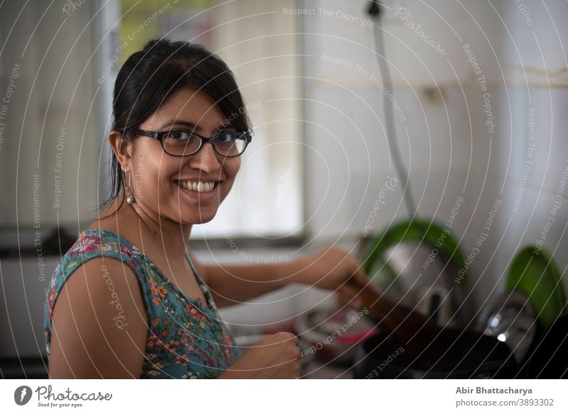 Indian Bengali beautiful brunette woman in casual dress standing inside her kitchen. Indian lifestyle adult asian attractive beauty bengali body caucasian