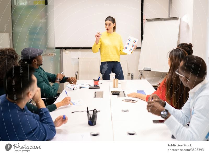 Group of colleagues discussing business strategy in conference room presentation success together meeting coworker collaborate cooperate multiracial multiethnic