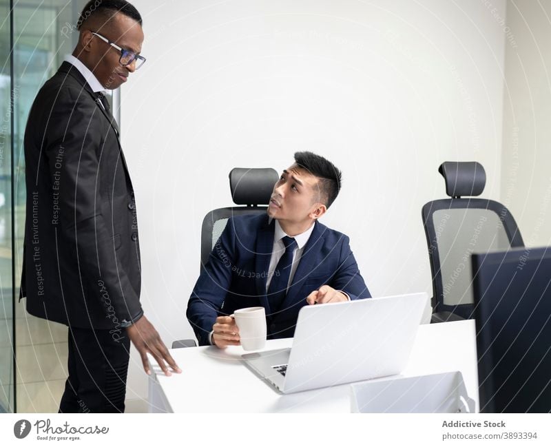 Business leader and manager discussing work problems in office businessmen boss laptop solution point show meeting serious young male asian african american