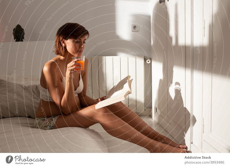 Serene pregnant woman reading book in morning pregnancy bed home literature expect female tranquil relax rest peaceful cozy soft glass juice comfort sit drink