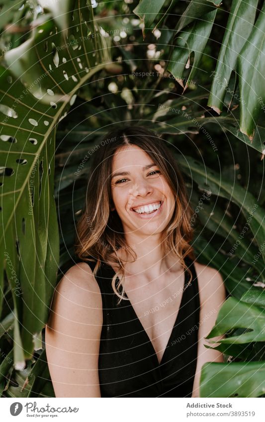 Optimistic woman in green tropical park monstera garden cheerful summer enjoy positive delight female exotic relax nature satisfied young greenery optimist