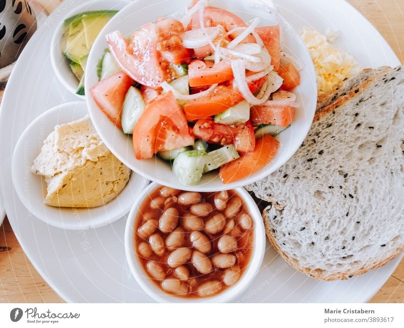 Top view of whole wheat bread, beans, avocado, hummus, vegan cheese and coconut yogurt with coffee for a full and healthy vegan breakfast hummus - food