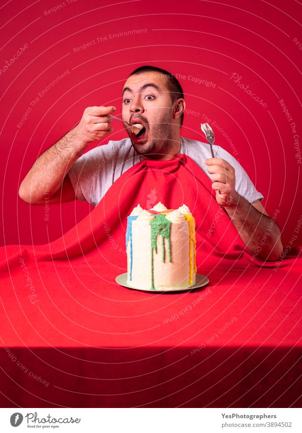 Man eating alone birthday cake. Greedy guy eating a huge cake. adult anniversary appetite big both hands buttercream cake celebrating celebration comfort food