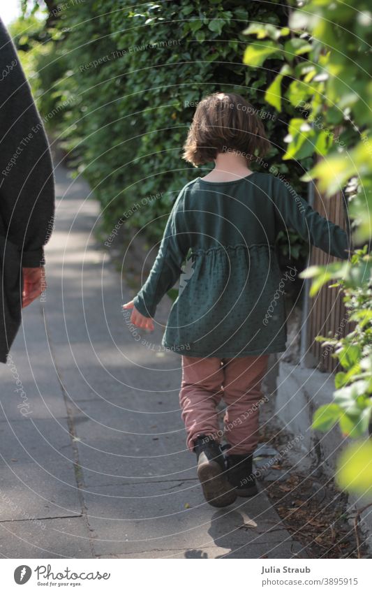 A girl goes for a walk stroll being out Autumn Summer Dress short hair Girl Garden fence Lanes & trails garden hedge Green Town walkway slab off Walking Dawdle