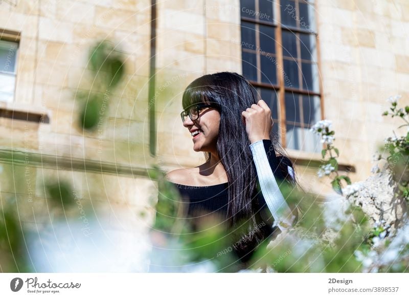 Portrait of beautiful young woman smiling while looking at camera standing in the street. outdoor person female lifestyle eyeglass happy girl portrait smile