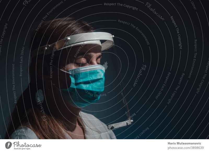 female doctor with face shield and mask, closed eyes, side view on dark background black background brazil corona epidemic corona virus covid-19 covid-19 test