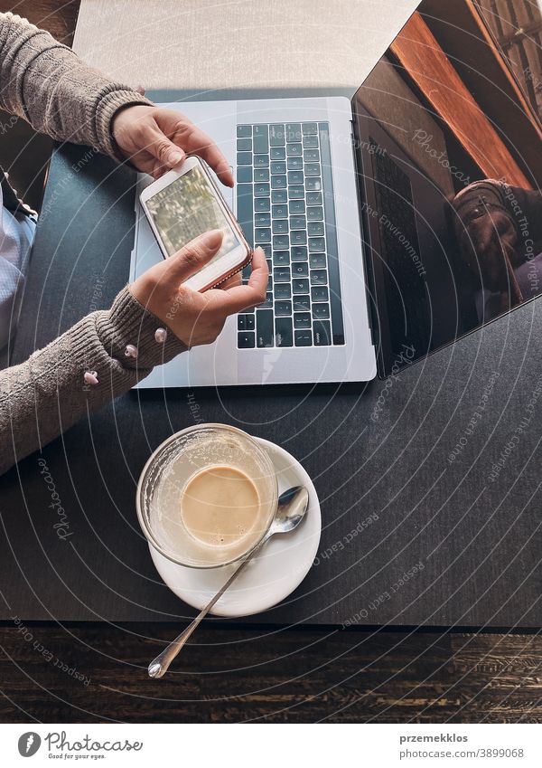 Woman working remotely on her laptop computer managing her work sitting in a cafe business caucasian coffee connection contemplate desk entrepreneur female