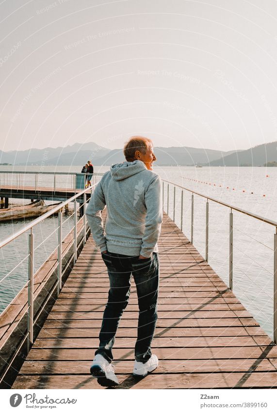 Sporty pensioner in the evening sun at lake Attersee Lake Attersee sunset Evening Sunset Nature Dusk Landscape Idyll Austria Footbridge Lakeside Exterior shot