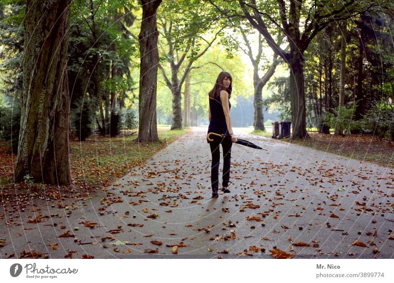 Looking back to the year 2020 Rear view Rotate Look back Attractive Long-haired Brunette Park Feminine pretty view over the shoulder Lanes & trails Umbrella