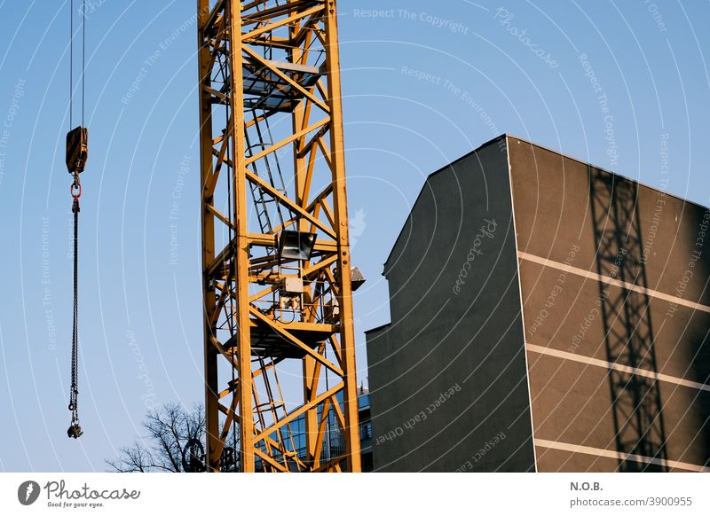 Detail of a crane and its shadow Crane Construction site Sky Blue Exterior shot Work and employment Build Workplace Economy Technology Profession