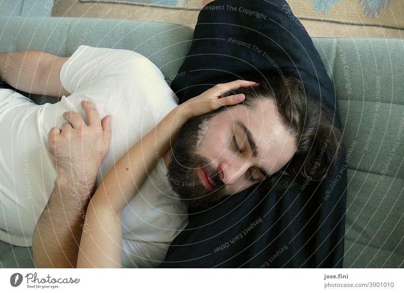 A man lies with his head in the lap of a woman Sit shot two youthful people Man Woman Calm Relaxation Cuddling Safety (feeling of) Together Interior shot