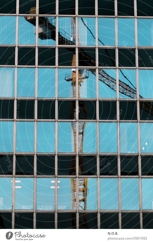 Reflection of a crane in an office façade Crane Construction site Sky Blue Exterior shot Work and employment Build Workplace Economy Technology Profession