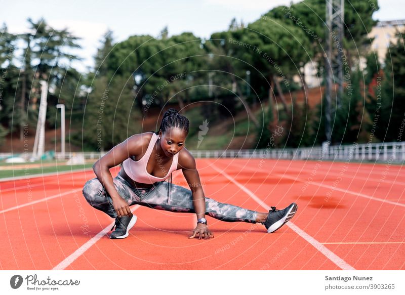 Athlete sprinter stretching her legs control race run competition athlete athletics competitive ready line beginnings compete competitor olympic olympics sports