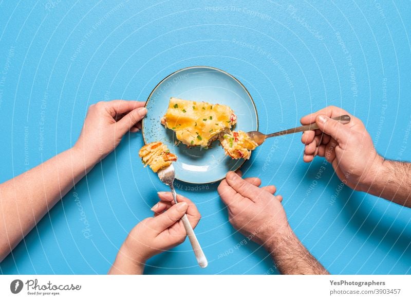 Vegetarian lasagna slice, top view. People eating a piece of lasagna above view baked goods bechamel sauce blue background carbs carrots cheese comfort food