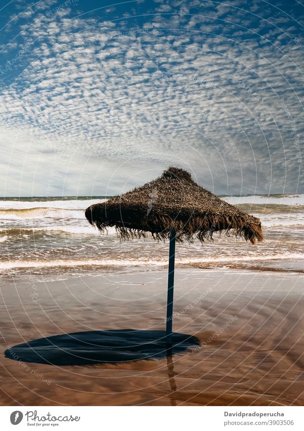 Lonely straw umbrella on seashore beach summer protect blue sky paradise sand exotic vacation travel nature tourism idyllic seaside coast resort tropical ocean