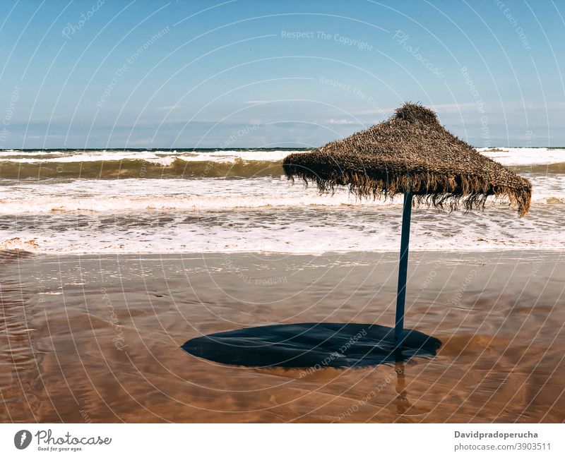 Lonely straw umbrella on seashore beach summer protect blue sky paradise sand exotic vacation travel nature tourism idyllic seaside coast resort tropical ocean